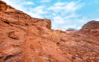 Red rocks and dust in Wadi Rum, Jordan desert - landscape that looks as different planet or science fiction movie set