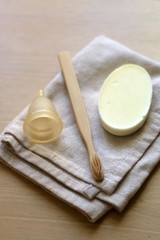 Linen cloth, soap, bamboo toothbrush and menstrual cup. Zero waste bathroom products. Selective focus.