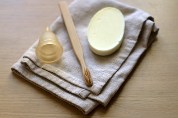 Linen cloth, soap, bamboo toothbrush and menstrual cup. Zero waste bathroom products. Selective focus.