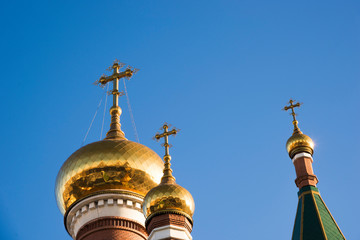 Fototapeta na wymiar Three domes of the Orthodox Church against the blue sky.