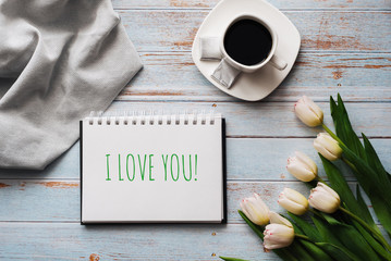 Greeting card with the inscription I Love You. Bouquet of white Tulip flowers with a Cup of coffee