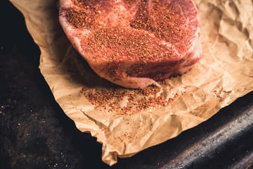 Raw fresh meat with spices on the rustic background. Selective focus. Shallow depth of field.