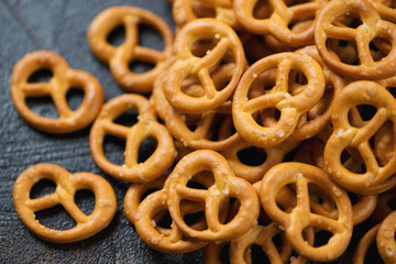 Close-up of pretzels snack on a dark brown stone surface, selective focus, horizontal shot