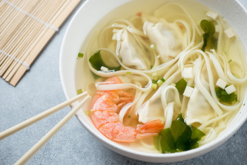 Bowl of wonton noodle soup with shrimp, close-up, elevated view, horizontal shot