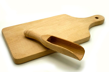 Wooden kitchen utensils on white background. Cutting board and scoop.