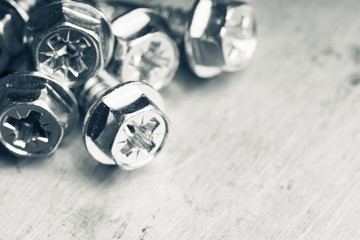 Tapping screw made of steel on the dark rustic background. Selective focus. Black and white image....