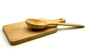 Wooden kitchen utensils on white background. Handcrafted cutting board and spoon.
