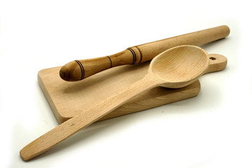 Wooden kitchen utensils on white background. Cutting board, spoon and scoop.
