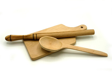 Wooden kitchen utensils on white background. Cutting board, spoon and scoop.