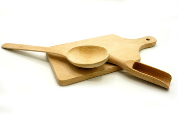 Wooden kitchen utensils on white background. Cutting board, spoon and scoop.