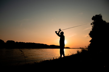 Men fishing on the river on sunset