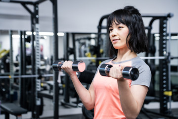 Fototapeta premium フィットネスジムで筋トレをする女性