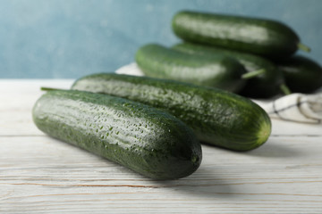 Cucumbers and towel on wooden background, close up
