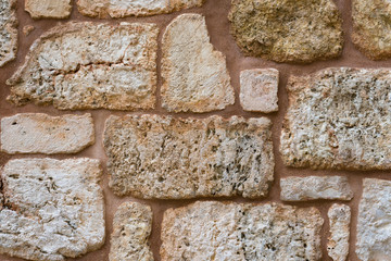 Texture of wall made of unevenly cut Jerusalem stones.