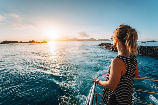 Arriving at La Digue Island, Seychelles. Young adult women enjoying sunset in ocean from Ferry boat deck
