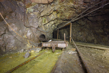 Naklejka premium Old copper mine underground tunnel with rails and cart
