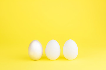 Easter colored bright eggs on a yellow background. Easter creative banner concept card. Copy space