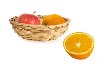 half  orange and wicker basket with apple and orange isolated on a white background. Healthy eating concept