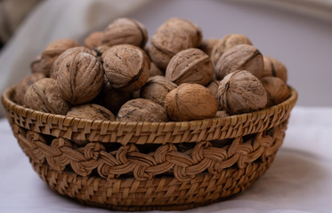 Walnut. Small wicker basket filled with walnuts on a white background