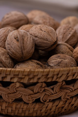 Walnut. Small wicker basket filled with walnuts on a white background