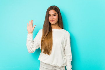 Young slim woman smiling cheerful showing number five with fingers.