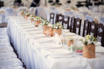 The festive table setting is decorated with flowers of roses in a rustic style.