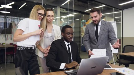 Good-looking satisfied multiethnic group of business people discussing together the further actions about joint business project
