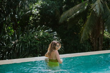 Young woman in infinity pool in the jungle in Ubud, Bali
