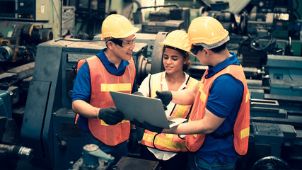 The scene of industrial inspectors team discussing using laptop checking the safety and review function in a metal factory, concept auditor safety, quality control in a factory, quality inspection.