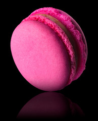 Macro photo of french pink rose macaroon isolated on black with clipping path
