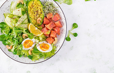 Ketogenic diet breakfast. Salt salmon salad with greens, cucumbers, eggs and avocado. Keto/paleo lunch. Top view, overhead