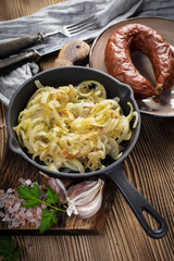 Fried onion in a cast iron skillet standing on a wooden countertop.