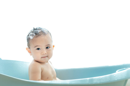 Cute baby taking a bath sitting in bathtub on white background,Hygiene and skin care for young children,Clean and healthy concept.