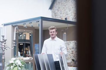Salesman standing in a shop next to flooring samples, Germany