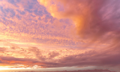 Naklejka na ściany i meble Orange sky with scattered clouds during sunset