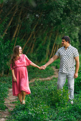 Fototapeta premium husband hugging pregnant wife in pink dress. expectant parents w