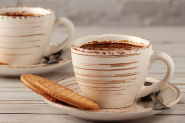 Two cups of aromatic coffee on an old white wooden table.