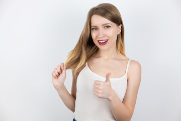 portrait of young beautiful blond woman looking happy and satisfied showing like sign touching her...