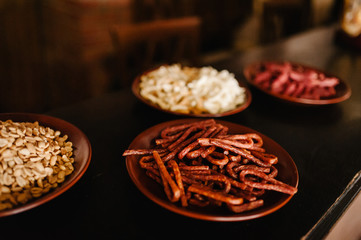 Snacks to beer in plate isolated on background table. Snacks, nuts, pistachios, rusks, dried meat.