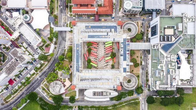 4K UHD hyperlapse time-lapse of bus terminal station and car traffic transport in Singapore city downtown. Drone aerial top view, fly upward. Commuter, Asia city life or public transportation concept