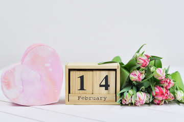February 14 text on wooden block calendar and pink Tulips. Greeting card with pink Tulips .Spring card template. Women's Day. Greeting card for mother's day. Flower card. Copy space. Selective focus