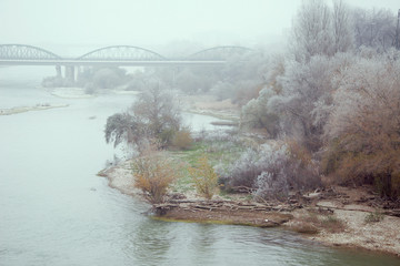 Fototapeta premium river with mist and bridge town in the background