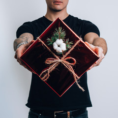 The guy holds in his hands a festive box with a gift. Soft toy. Gifts. Holiday.