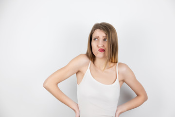 portrait of young beautiful blond woman looking shocked grimacing on isolated white background, healthcare and beauty concept