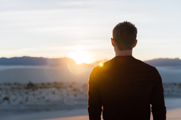 A man looking into the sunset at White Sands National Park in New Mexico. 