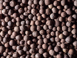 Allspice peas top view, repeating elements. Hard light. Texture.