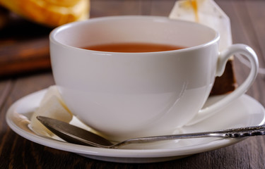 Fresh and rosy buns with cherry on a wooden table and a cup with fragrant tea.