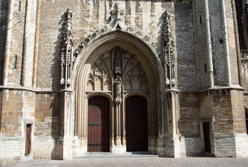 Fototapeta na wymiar Entrance to the Saint Bavo cathedral in the historic Belgium city of Ghent. Ornate stone carvings decorate the building.