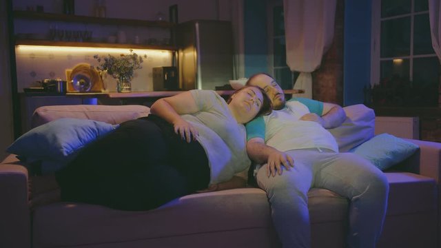 Stout couple re sleeping on comfortable sofa together at home