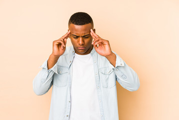 Young latin man isolated on beige background touching temples and having headache.